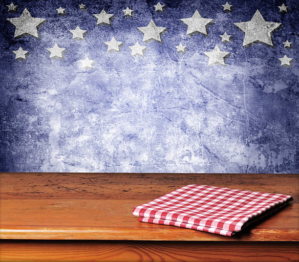 Folded gingham cloth on table with blue starred background Empty wooden deck table with tablecloth for USA holidays background montages patriotic quilt stock pictures, royalty-free photos & images
