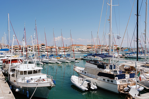 A lively marina filled with an array of boats and yachts, masts soaring into the clear blue sky, reflecting the vibrant nautical life