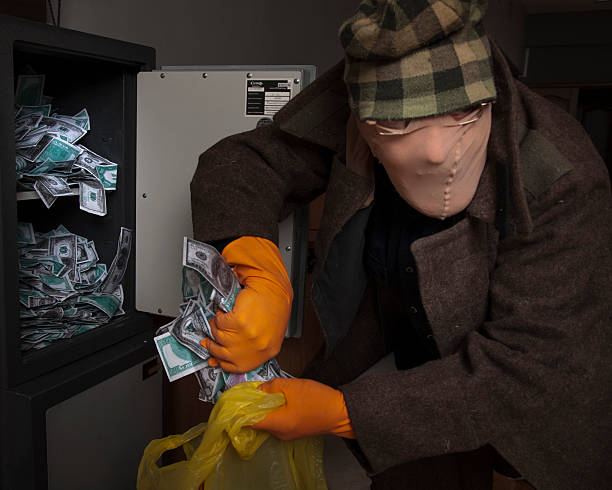 istock thief steals money from the safe 184823468
