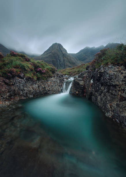 istock Morning view of river with waterfall and cloud covered mountain range 1848258407