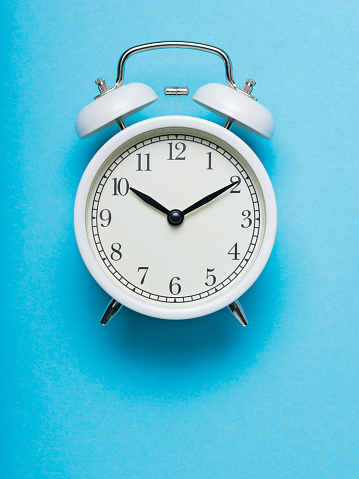 White Alarm Clock on Blue Background, Time Concept, Copy Space