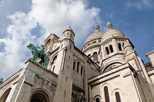 In Paris, France on a winter day the landmark Basilique Du Sacre Coeur cathedral architecture towers on top of a hill in Montmartre