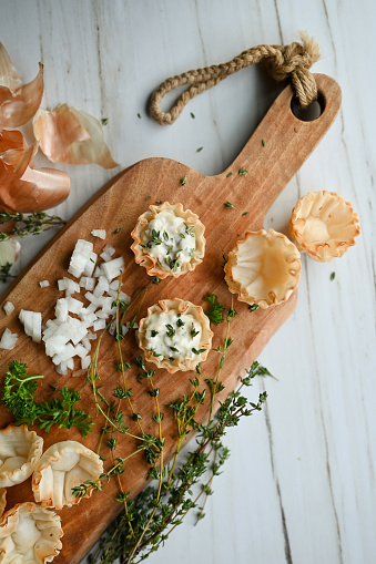 Preparing French Onion Tartlets Before Baking