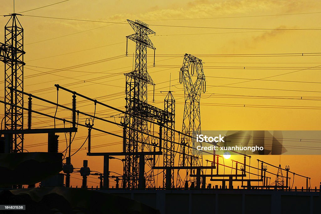 Electricity network at transformer station in sunrise Impression network at transformer station in sunrise, high voltage up to yellow sky. Electricity Transformer Stock Photo