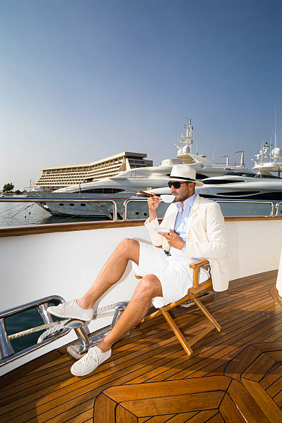 Elegant Businessman on board of the yacht drinking coffee stock photo