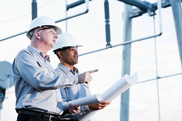 Multiracial engineers at industrial site looking up
