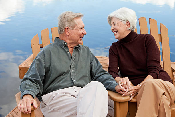 istock Happy senior couple sitting by water 184832477