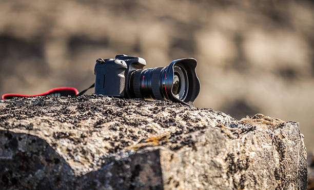 istock Close-up of a DSLR camera sitting on a rock 184832574