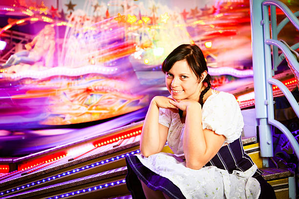 young woman sitting next to brightly colored carousel