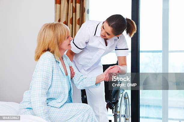 Infermiere Aiutando Una Donna Anziana Su - Fotografie stock e altre immagini di Visita a domicilio - Visita a domicilio, Ospedale, Sedia a rotelle