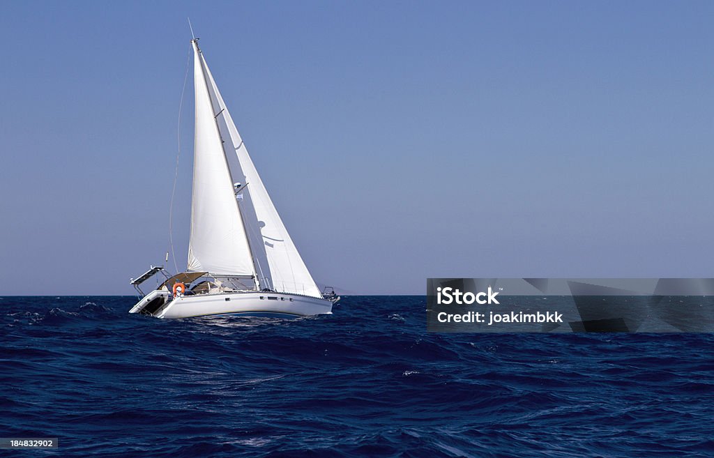 Boat sailing in the open ocean Sailing boat at sea (Mediterranean sea) with clear blue sky.Further choices below: Adventure Stock Photo