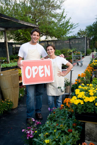 inscription pour les dirigeants de petites entreprises tenant panneau ouvert en dehors des plantes nur - sc0411 photos et images de collection