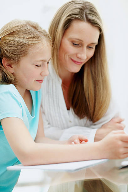 istock Mother helping cute daughter with homework 184833313