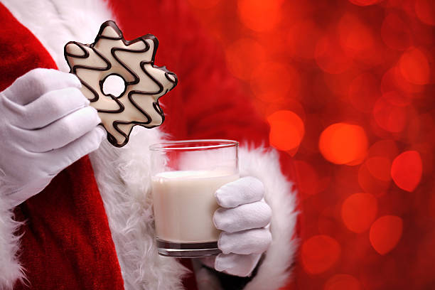 Santa holding Natale biscotti e latte - foto stock