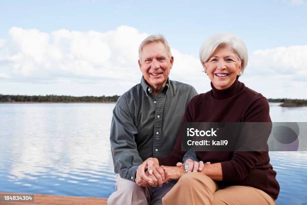 Pareja Mayor Sentado En Agua Foto de stock y más banco de imágenes de 60-69 años - 60-69 años, Adulto, Agarrados de la mano