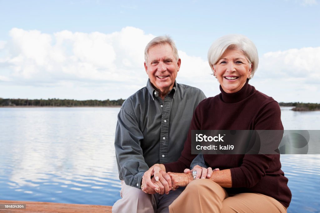 couple âgé assis au bord de l'eau - Photo de Adulte libre de droits