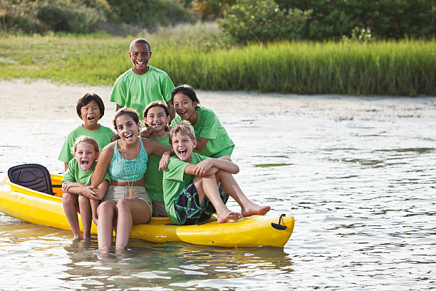 ajudante de colônia de férias de verão e crianças, sentado no caiaque - summer camp child teenager kayak - fotografias e filmes do acervo