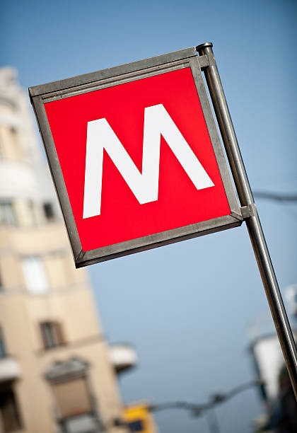 Milan Metro Sign with apartment building in background stock photo