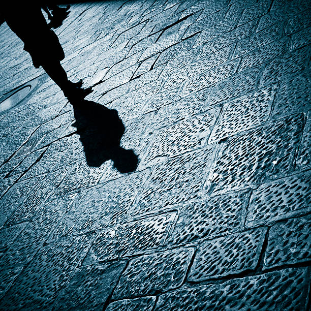 Solitary Man is Watching You Shadow of a  solitary man on the ancient stone flooring of Florence (Tuscany, Italy). creepy stalker stock pictures, royalty-free photos & images