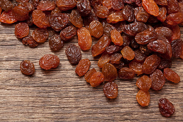 Dried raisins Closeup of dry grape (dried raisins) on the wooden plank; Adobe RGB color space;see other similar images: raisin stock pictures, royalty-free photos & images