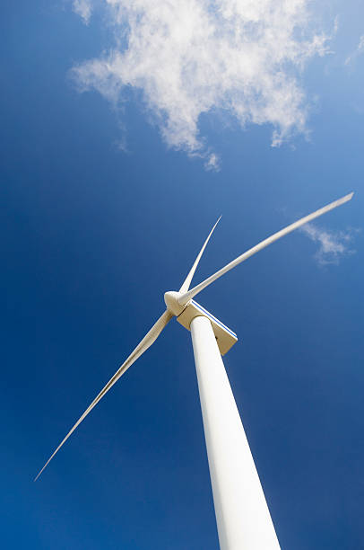 Wind turbine against blue sky stock photo