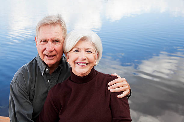 istock Senior couple sitting by water 184836716