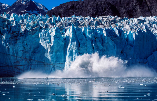 Margerie Glacier, in the Glacier Bay waterway, calving into the Tar Inlet, causing a huge disruption on the calm water surface.Taken in Glacier Bay, Tar Inlet, Southeast Alaska, USA