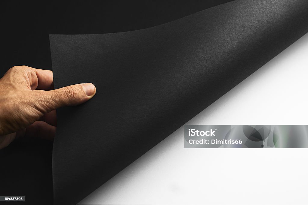 Revealing... Male hand turning a page of black paper revealing the white space where you can add your own concept image.Related pictures: Achievement Stock Photo