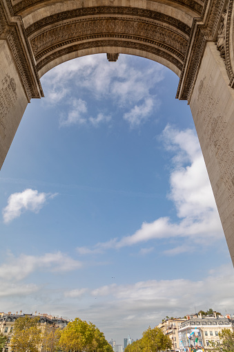 Low-angle view of Arc de Triomphe on The Place Charles de Gaulle in Paris, France.
