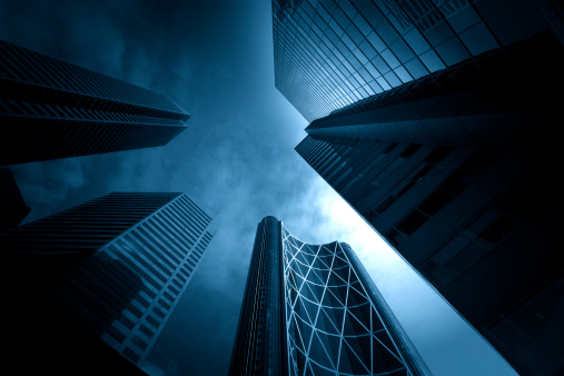 Low angle view of menacing skyscrapers at night.