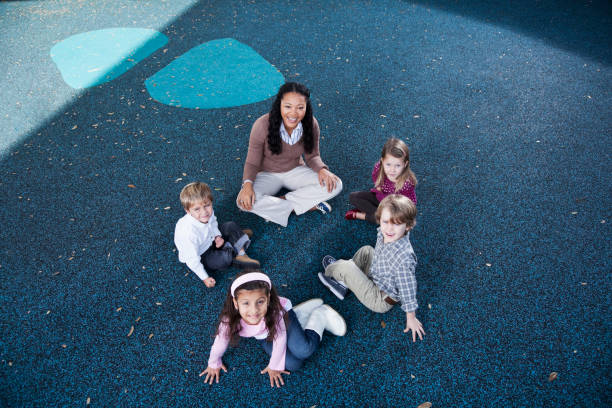 bambini in età prescolastica seduti in cerchio con insegnante - circle child preschool preschooler foto e immagini stock