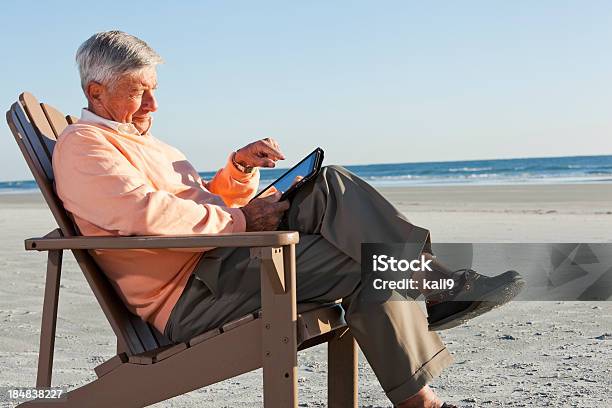 Uomo Anziano Usando Tablet Digitale Sulla Spiaggia - Fotografie stock e altre immagini di Lettore di libri elettronici - Lettore di libri elettronici, Spiaggia, Terza età