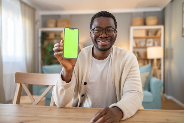 istock Black young man shows mobile phone with green screen, Chroma screen 1848384522