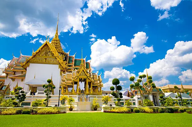 "Royal Palace and Chakri Maha Prasat Throne Hall at the Grand Palace same area with Wat Phra Kaeo, Bangkok, Thailand. The Emerald Buddha temple. Dramatic cloudscape with blue sky and cumulus clouds over the Grand Palace.See more images like this in:"