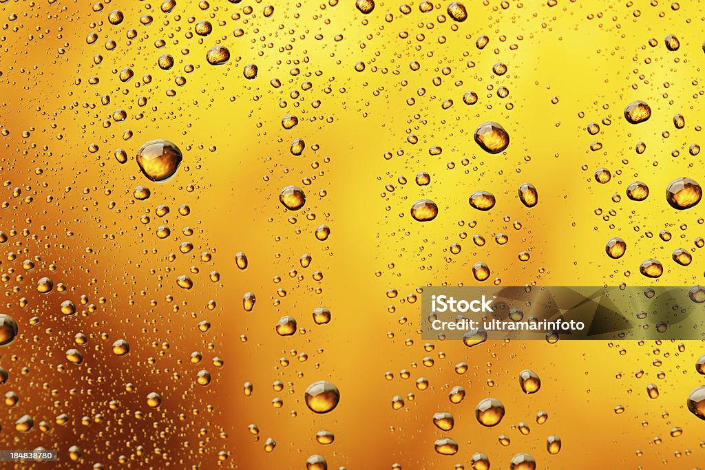 Water drops background "Ice Cold  Glass , covered with water drops - condensation. The background is clear with the emphasis on water drops on yellow-golden background. Close - up. Very shallow DOF, defocused with Canon 90mmTS + 1DS mkIII. The grain and texture added.SEE ALSO:" Beer - Alcohol Stock Photo