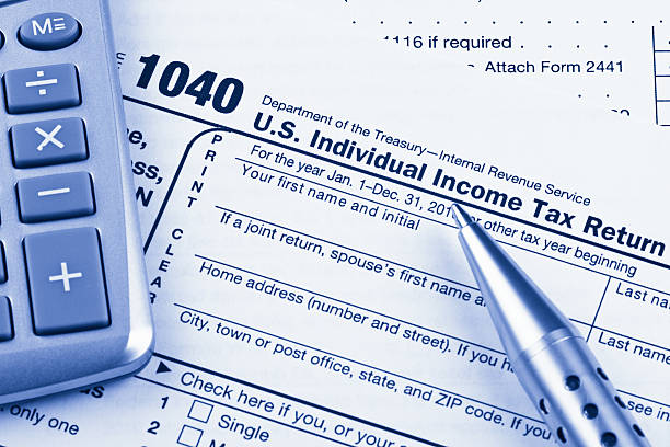 istock US 1040 Tax Return Form with Calculator and Pen 184838918