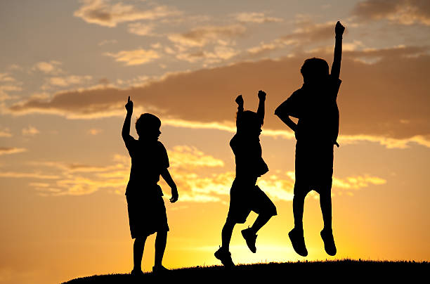 istock Silhouette of Three Children Jumping for Joy 184838947