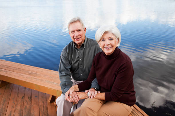 istock Senior couple sitting by water 184839092