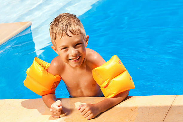 istock Boy with water wings in the swimming pool 184839363