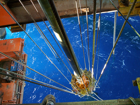 The moonpool and riser of a semisubmersible drilling rig. Large fish visible in waterMore oilfield images: