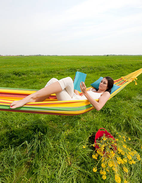 istock woman reading magazine in hammock 184841349