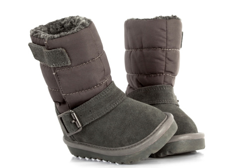 Pair of cute grey child's winter boots, white background, soft natural shadows