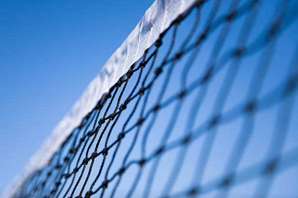 close-up tennis and net on court with sunlight in background