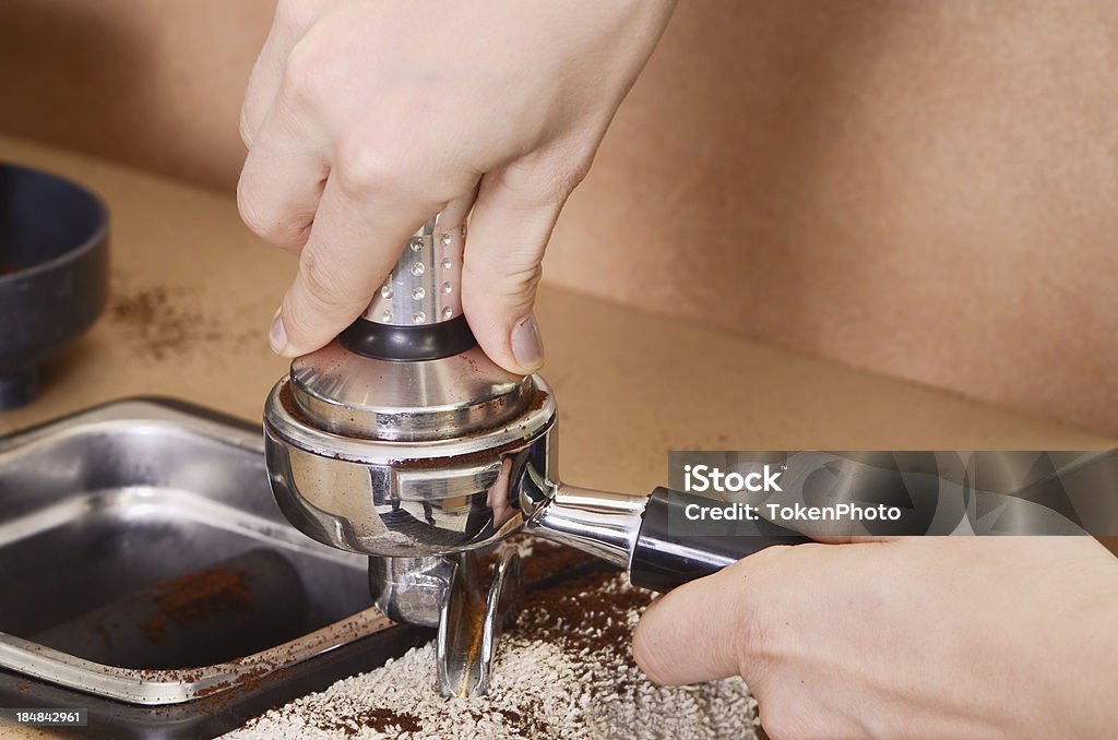 Tamping Espresso Tamping a portafilter with coffee beans to make an espresso. Coffee - Drink Stock Photo