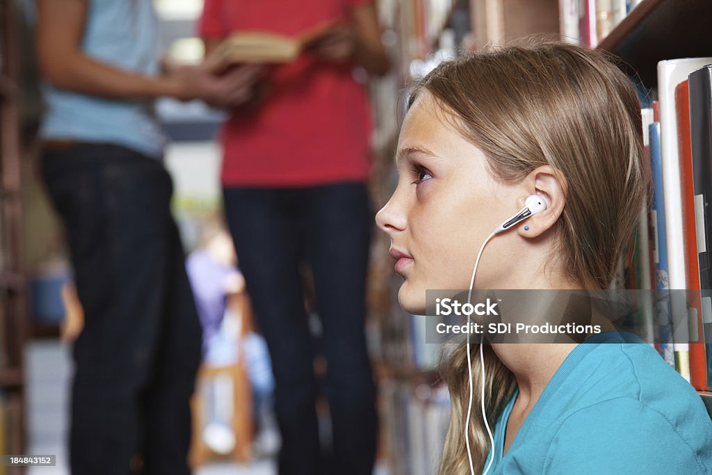 Jovem estudante em uma biblioteca ouvir música - Foto de stock de Acontecimentos da Vida royalty-free