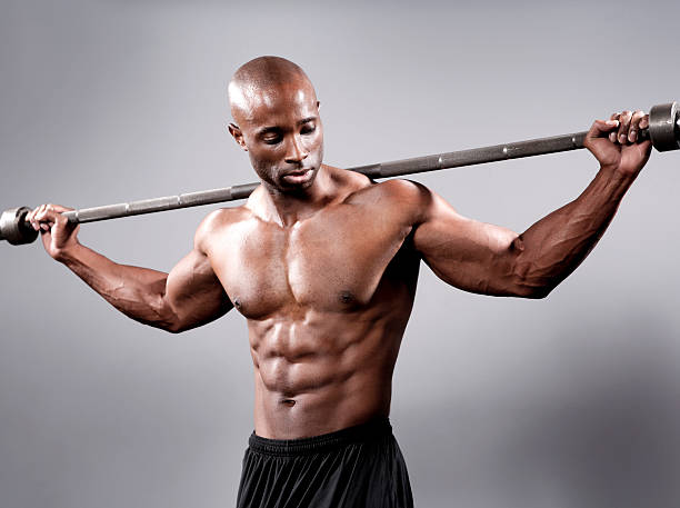 bodybuilder in posa con peso bar - men black body building african descent foto e immagini stock