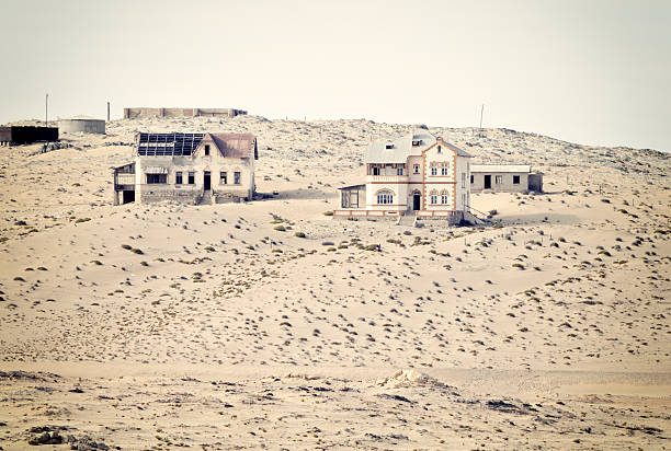 Old, abandoned buildings in a remote, dusty landscape.  Abandoned buildings in Kolmanskop,a ghost town in the restricted diamond mining area,Luderitz,Namibia. kolmanskop namibia stock pictures, royalty-free photos & images