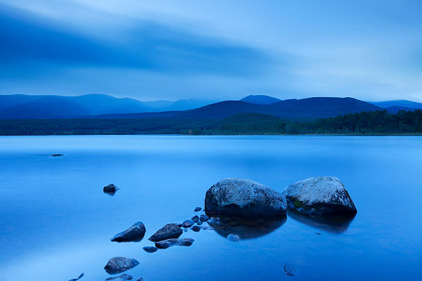 Still lake at dawn, Loch Morlich, Cairngorms, Scotland "A beautiful lake photographed in the blue hour at dawn. Photographed at Loch Morlich, Cairngorms, Scotland." cairngorm mountains stock pictures, royalty-free photos & images