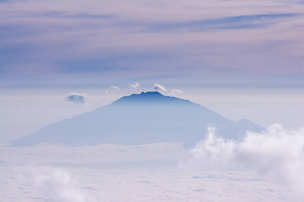 Mount Meru towering over morning haze. Tanzania