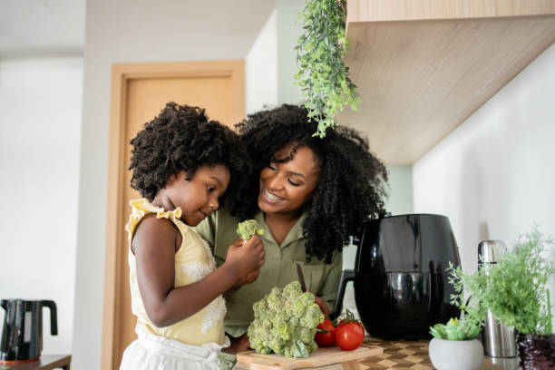 istock Mother teaching daughter how to prepare vegetables 1848434700
